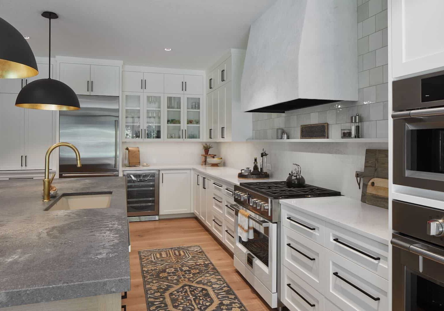 custom kitchen with white cabinets, gas stove and beautiful countertops